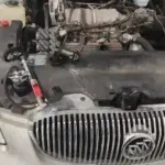 2007 Buick Lucerne undergoing coolant leak repair with the hood open in Broken Arrow, OK