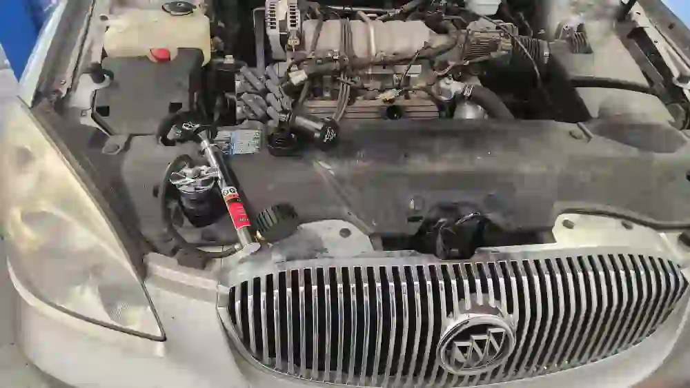 2007 Buick Lucerne undergoing coolant leak repair with the hood open in Broken Arrow, OK