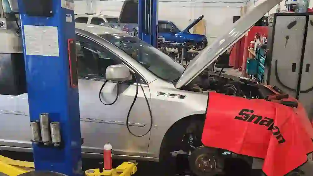 Buick Lucerne on a lift for steering rack and coolant system repair in Broken Arrow