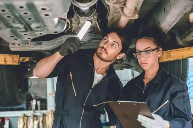 Auto mechanic team working help support together to checking under car for service maintenance in ga