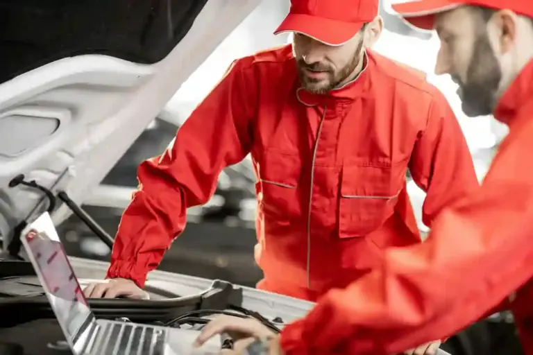 Auto mechanics doing diagnostics with laptop