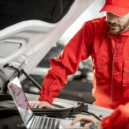 Auto mechanics doing diagnostics with laptop