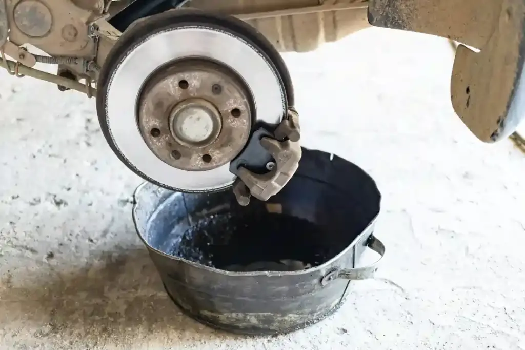 brake fluid is drained into basin in car workshop