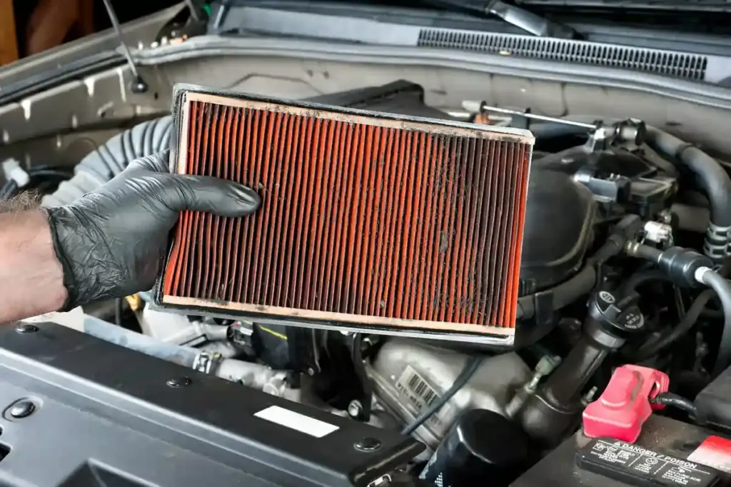 Car air filter being removed for inspection and replacement.