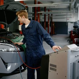 Repairman at car garage doing air conditioner or climate control servicing