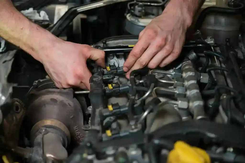 Technician removing fuel injectors checking dust and test pressure.