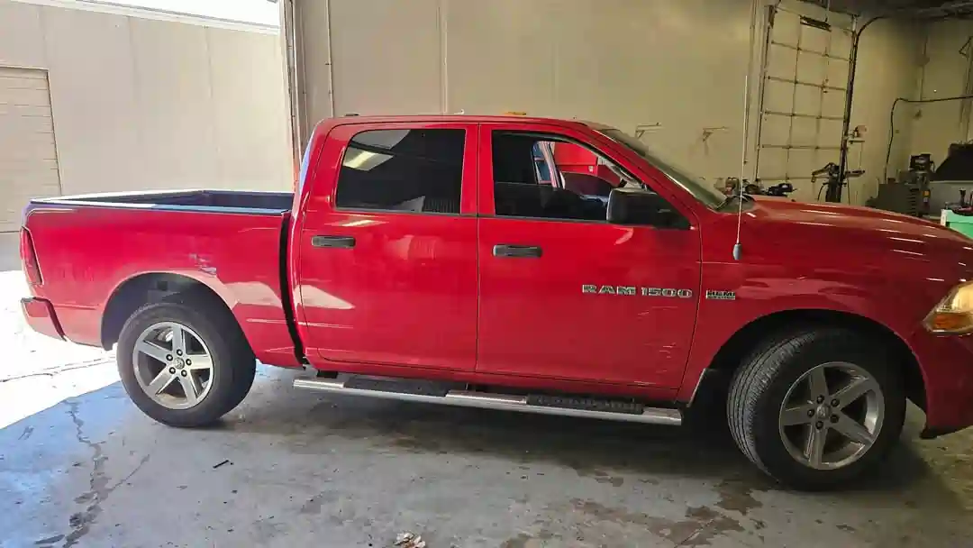 Side view of a red 2012 Dodge Ram 1500 at T Autocare Takedown in Broken Arrow for a pre-purchase vehicle inspection